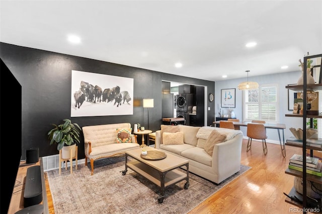 2309 Magellan St, Colorado Springs, CO 80907 - living area with stacked washer and clothes dryer, light wood-style floors, an accent wall, and recessed lighting