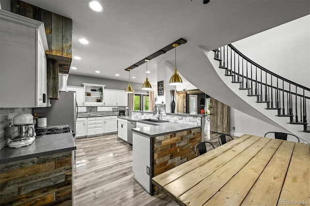 kitchen featuring dishwasher, a sink, backsplash, open shelves, and recessed lighting