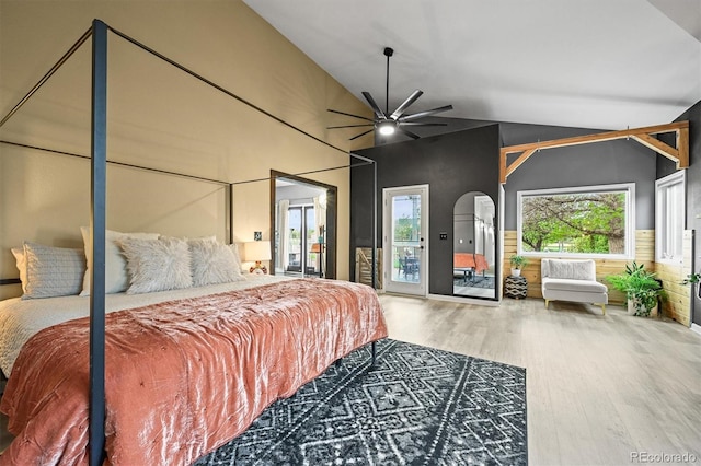 bedroom featuring wood finished floors, access to exterior, lofted ceiling, arched walkways, and ceiling fan