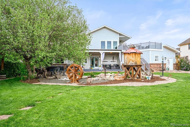 back of house featuring a lawn and a patio area