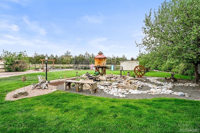view of jungle gym featuring a storage shed, a yard, and an outdoor structure