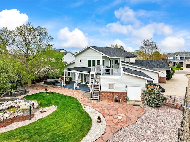 rear view of house with a patio, stairway, driveway, roof with shingles, and a covered hot tub
