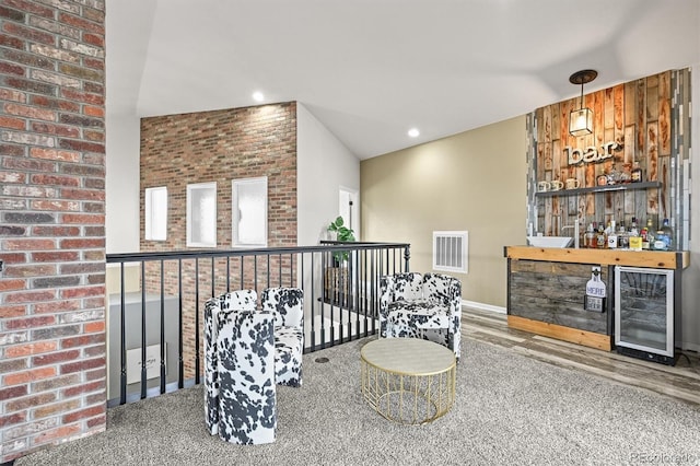 sitting room with a dry bar, wine cooler, lofted ceiling, wood finished floors, and recessed lighting