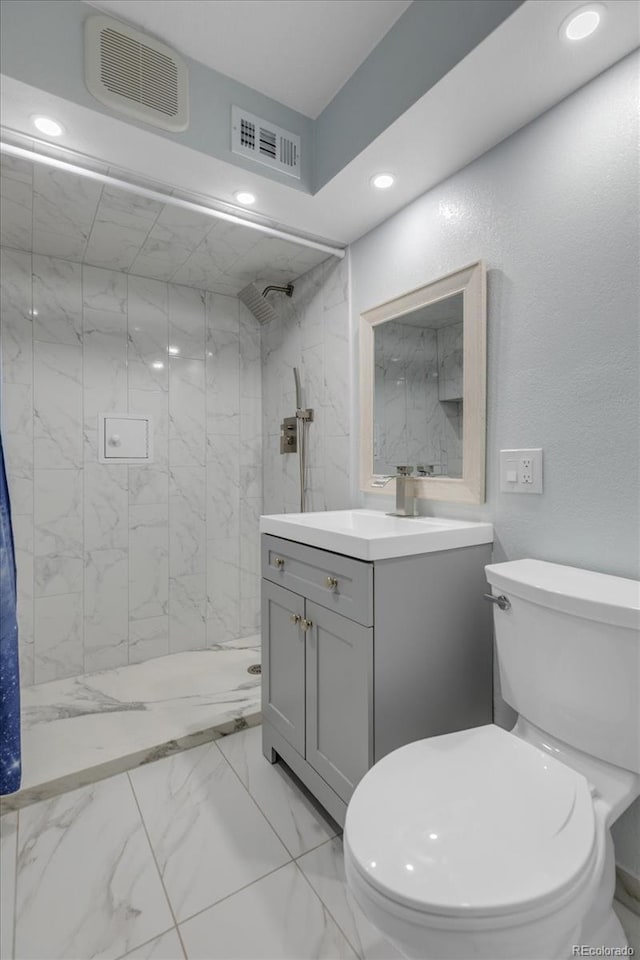 1304 Ceres Dr, Lafayette, CO 80026 - full bath featuring toilet, marble look tile flooring, vanity, a tile shower, and recessed lighting