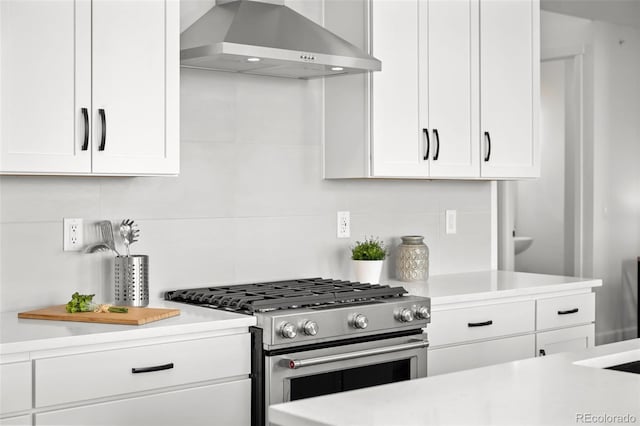 8242 S Pierson St, Littleton, CO 80127 - kitchen featuring stainless steel range with gas cooktop, white cabinetry, light countertops, and wall chimney exhaust hood
