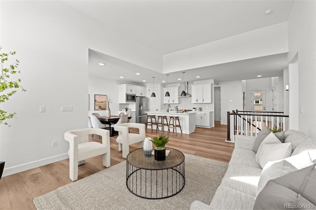 8242 S Pierson St, Littleton, CO 80127 - living room with a towering ceiling, baseboards, light wood-type flooring, and recessed lighting
