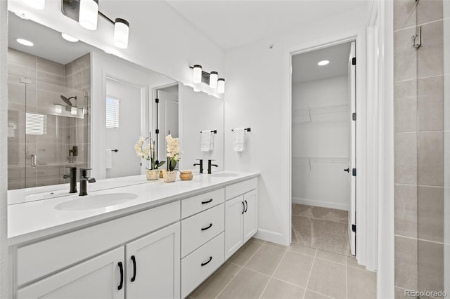8242 S Pierson St, Littleton, CO 80127 - full bathroom featuring a stall shower, a sink, tile patterned flooring, double vanity, and a spacious closet