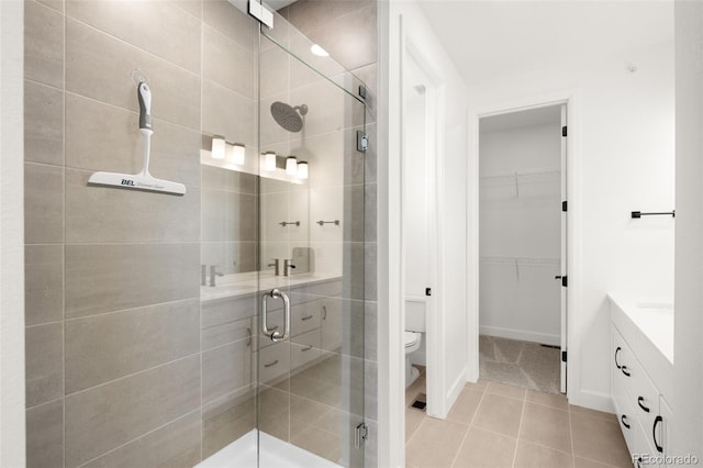 8242 S Pierson St, Littleton, CO 80127 - bathroom with a stall shower, baseboards, toilet, tile patterned flooring, and a walk in closet