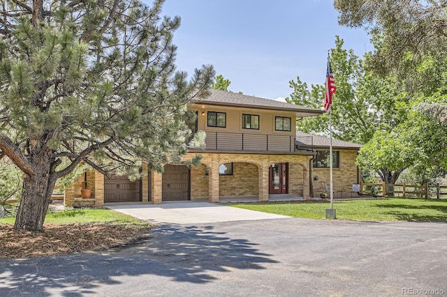12196 W Belleview Dr, Littleton, CO 80127 - view of front of house featuring a balcony, concrete driveway, a garage, a shingled roof, and stucco siding