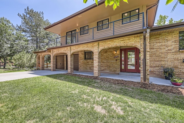 12196 W Belleview Dr, Littleton, CO 80127 - view of front of property featuring a balcony, driveway, a front lawn, a garage, and brick siding