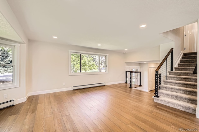 12196 W Belleview Dr, Littleton, CO 80127 - unfurnished living room with a baseboard heating unit, stairs, plenty of natural light, wood finished floors, and recessed lighting