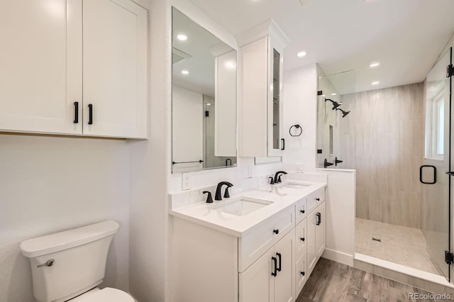 12196 W Belleview Dr, Littleton, CO 80127 - full bath featuring a stall shower, double vanity, toilet, wood finished floors, and recessed lighting