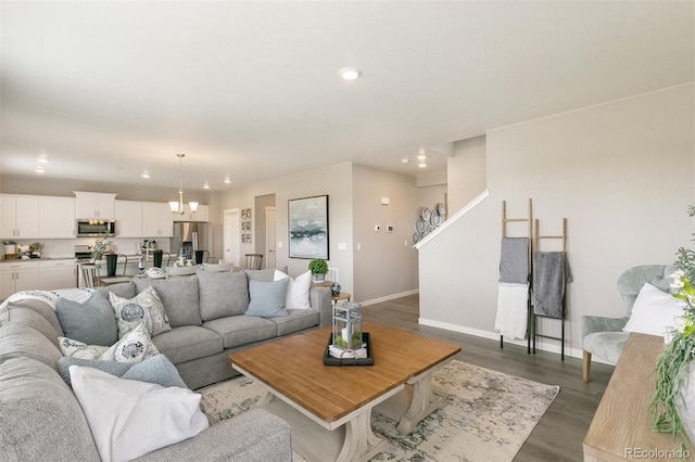 living room featuring an inviting chandelier and dark hardwood / wood-style flooring