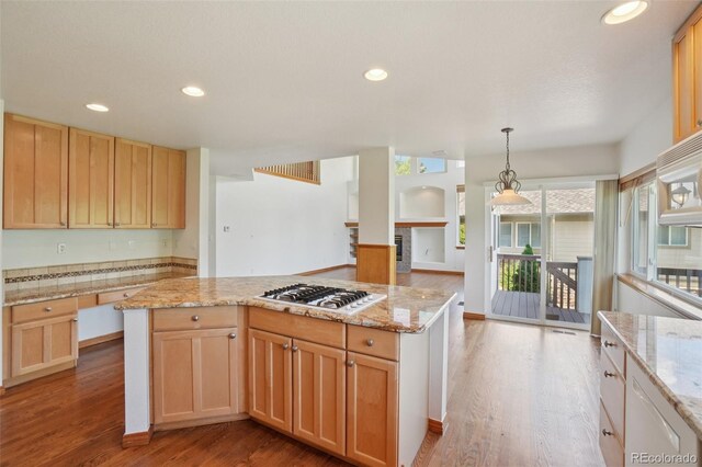 2247 Eagles Nest Dr, Lafayette, CO 80026 - kitchen featuring gas cooktop, wood finished floors, a kitchen island, light stone counters, and recessed lighting