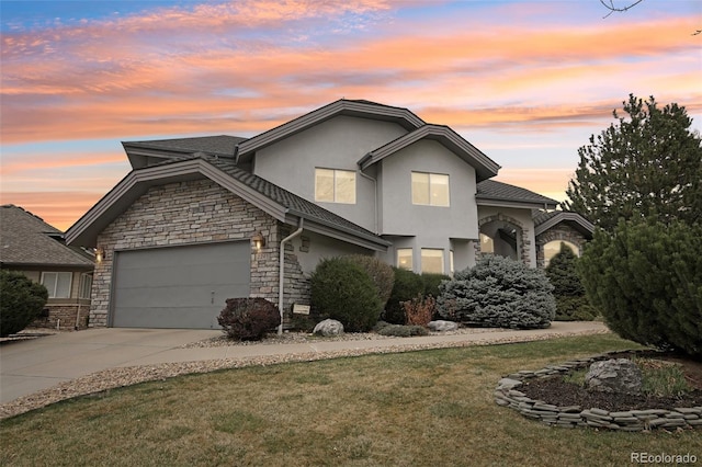 2247 Eagles Nest Dr, Lafayette, CO 80026 - traditional-style house featuring stucco siding, stone siding, an attached garage, driveway, and a front yard
