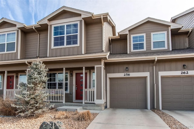 view of property featuring a porch, an attached garage, and driveway