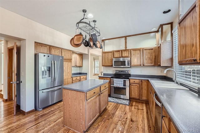 kitchen featuring wood-type flooring, a center island, sink, and stainless steel appliances