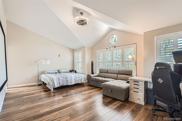 bedroom with vaulted ceiling and dark hardwood / wood-style flooring