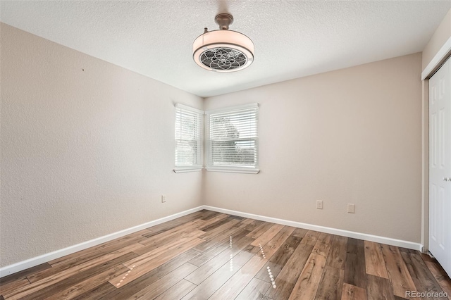 unfurnished bedroom featuring wood-type flooring, a textured ceiling, and a closet