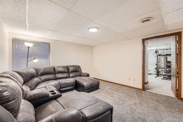 carpeted living room featuring a drop ceiling