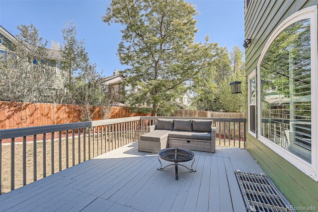 wooden terrace with an outdoor living space with a fire pit