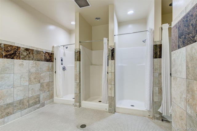 3022 S Wheeling Way Unit 107, Aurora, CO 80014 - bathroom featuring tile walls, a shower stall, and tile patterned flooring