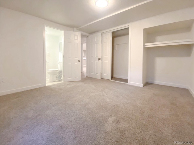 unfurnished bedroom featuring carpet floors and ensuite bathroom