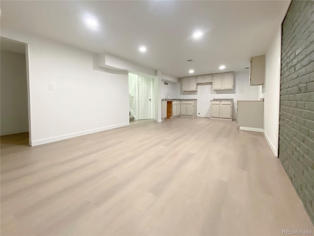 unfurnished living room featuring light wood-type flooring and sink