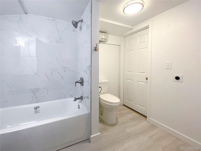 bathroom with hardwood / wood-style floors, tiled shower / bath combo, and toilet