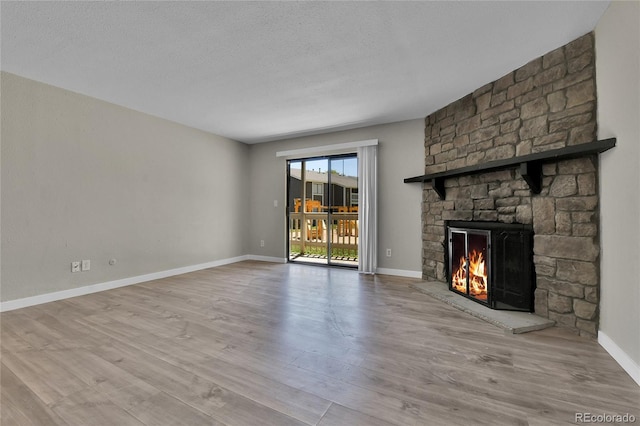 18034 E Ohio Ave Unit 104, Aurora, CO 80017 - unfurnished living room featuring a fireplace, wood finished floors, and a textured ceiling