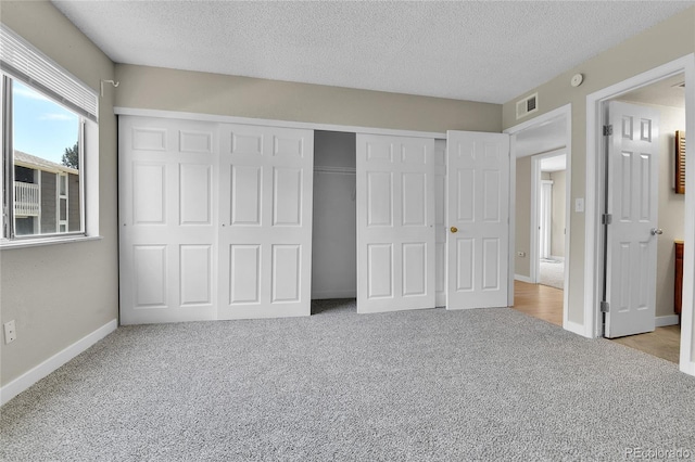 18034 E Ohio Ave Unit 104, Aurora, CO 80017 - unfurnished bedroom with carpet, a textured ceiling, and a closet