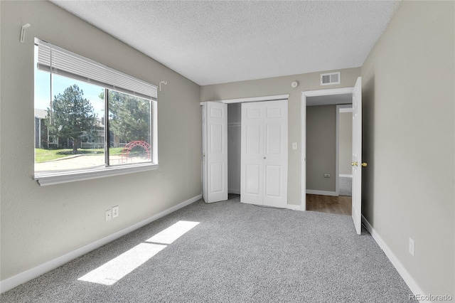 18034 E Ohio Ave Unit 104, Aurora, CO 80017 - unfurnished bedroom with carpet flooring, a textured ceiling, and a closet