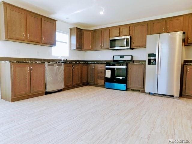 kitchen featuring appliances with stainless steel finishes and dark stone countertops