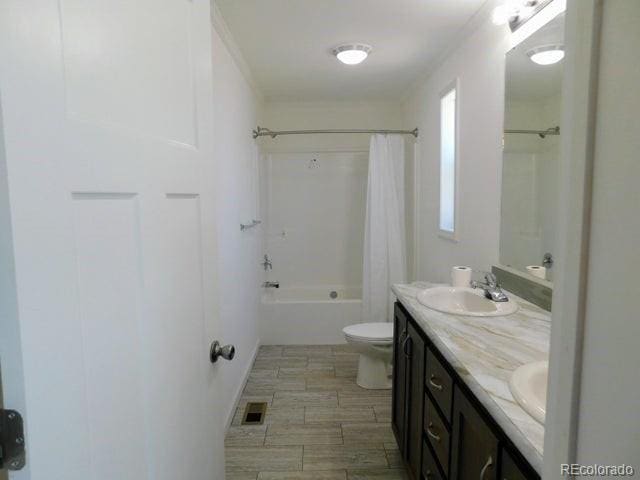 full bathroom with shower / tub combo, double sink vanity, and toilet