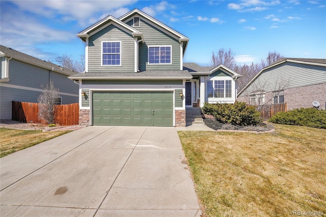 view of front of home featuring driveway, stone siding, fence, a front yard, and an attached garage