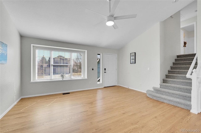 foyer entrance featuring light wood finished floors, visible vents, ceiling fan, stairs, and lofted ceiling