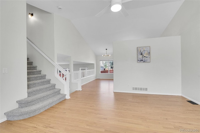 interior space featuring ceiling fan with notable chandelier, stairway, light wood-style floors, and visible vents