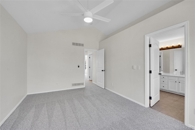 unfurnished bedroom featuring lofted ceiling, light colored carpet, and visible vents