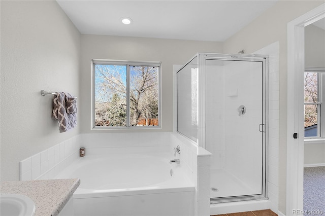 full bathroom with vanity, a bath, a healthy amount of sunlight, and a stall shower