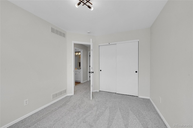 unfurnished bedroom with visible vents, baseboards, a closet, and carpet flooring