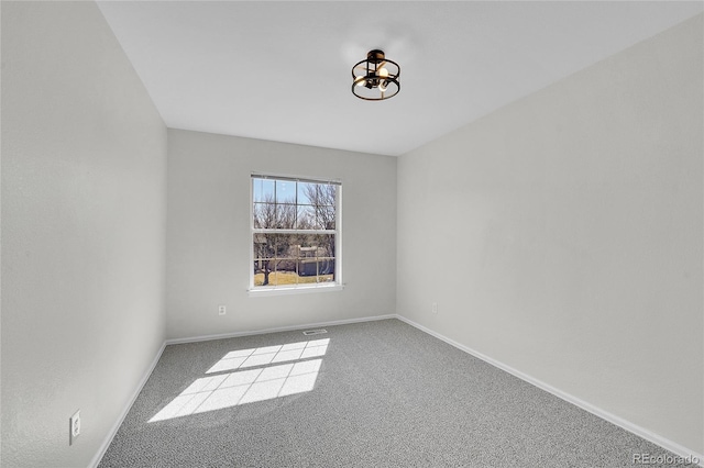 empty room with visible vents, baseboards, carpet, and a chandelier