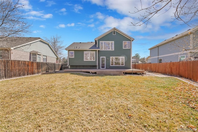 back of house featuring a lawn, a wooden deck, and a fenced backyard