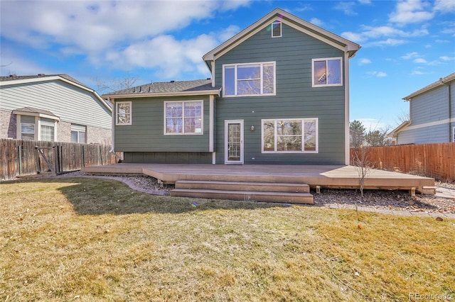 back of house featuring a deck, a lawn, and a fenced backyard