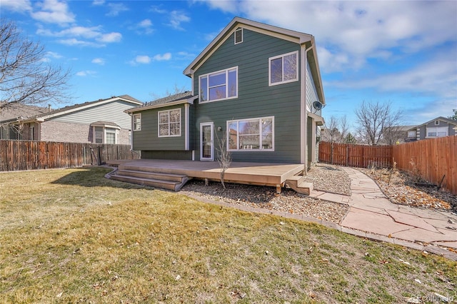 rear view of house with a yard, a deck, and a fenced backyard