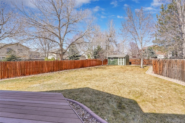 view of yard featuring a storage shed, an outbuilding, and a fenced backyard