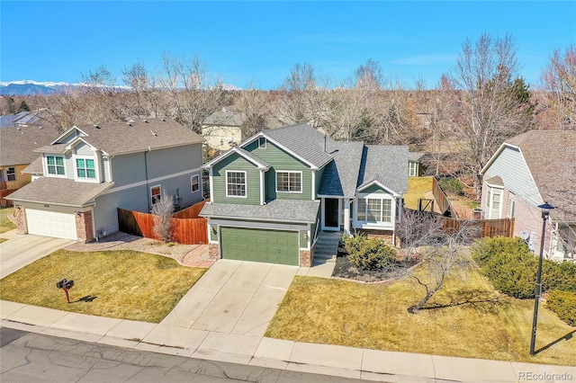 traditional home with concrete driveway, fence, a garage, and a front lawn