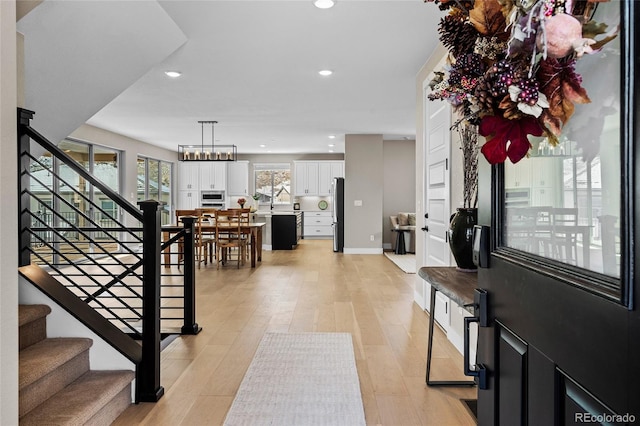 entrance foyer featuring light hardwood / wood-style floors and a notable chandelier