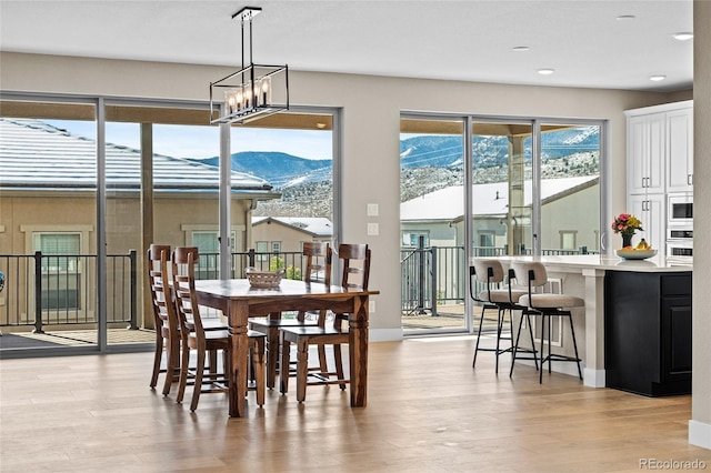 dining area featuring a notable chandelier, a mountain view, and light hardwood / wood-style floors