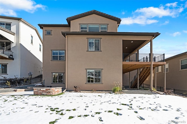 snow covered house featuring a deck