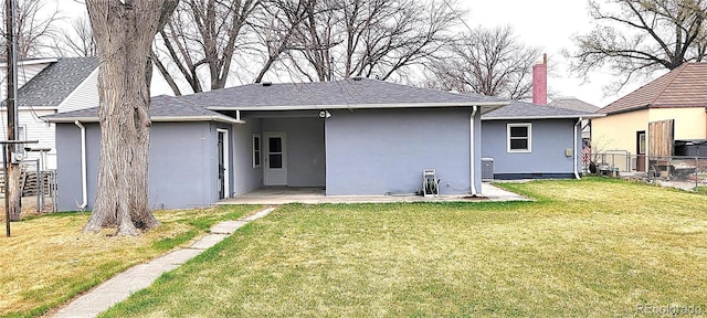 315 W 5th St, Julesburg, CO 80737 - back of property featuring a chimney, fence, a lawn, and stucco siding